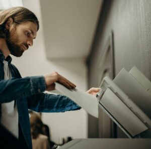 Un homme utilise le copieur pour scanner un document